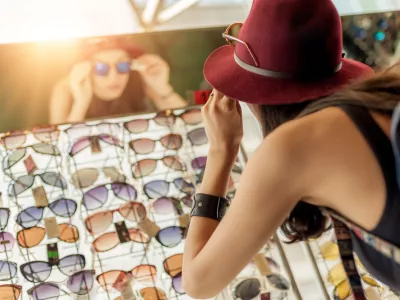 Happy woman buying sunglasses in shop on the street / Foto: Guruxoox Getty Images
