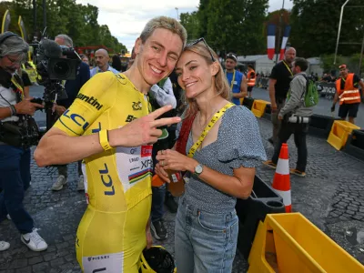 Slovenia's Tadej Pogacar, wearing the overall leader's yellow jersey, celebrates with his girlfriend Urska Zigart after the the last stage of the Tour de France cycling race in Paris, Sunday, July 26, 2026. (AP Photo/Dario Belingheri/Pool Photo via AP)