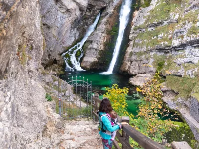 Alpine waterfall Savica in the nation park Triglav, Slovenia. Mother carrying baby in front. / Foto: Blazekg Getty Images