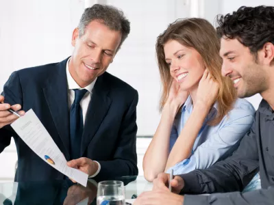 Happy young couple discussing with a financial agent their new investment.