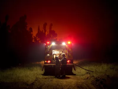 Firefighters prepare to fight flames caused by wildfires in Puren, Chile, Saturday, Saturday, Feb. 4, 2023. Forest fires are spreading in southern and central Chile, triggering evacuations and the declaration of a state of emergency in some regions. (AP Photo/Matias Delacroix)