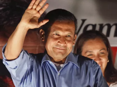 Presidential candidate Ollanta Humala waves to supporters from the balcony of his headquarters after polls closed for general elections in Lima, Peru, Sunday April 10, 2011. Unofficial results showed Humala won the most votes in Sunday's presidential vote and is headed into a runoff against Keiko Fujimori, the daughter of imprisoned former President Alberto Fujimori. Peru will hold a presidential runoff election on June 5. (AP Photo/Martin Mejia)