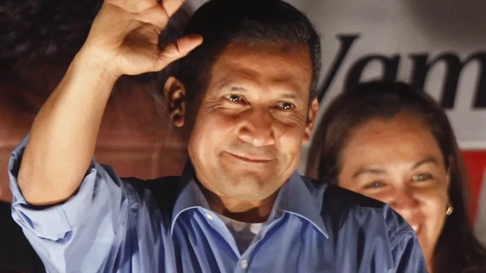 Presidential candidate Ollanta Humala waves to supporters from the balcony of his headquarters after polls closed for general elections in Lima, Peru, Sunday April 10, 2011. Unofficial results showed Humala won the most votes in Sunday's presidential vote and is headed into a runoff against Keiko Fujimori, the daughter of imprisoned former President Alberto Fujimori. Peru will hold a presidential runoff election on June 5. (AP Photo/Martin Mejia)