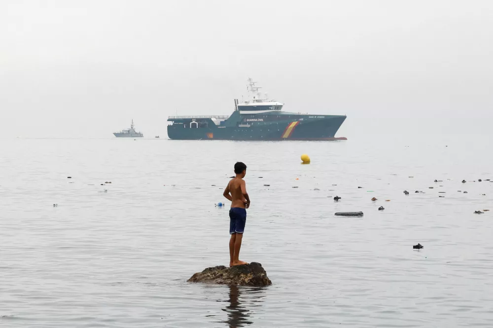 A youth from Morocco stands on a rock in the water, looking towards a Spanish Guardia Civil vessel, amid mass crossings of migrants on foot and by sea from Morocco into Spanish territory in Ceuta, Spain, July 31, 2026. REUTERS/Jon Nazca   TPX IMAGES OF THE DAY