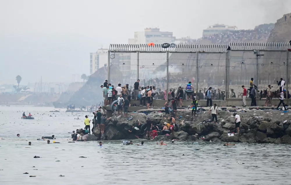 Migrants from Morocco gather by the border fence as they cross the Spanish border, swimming through the sea, as seen from Ceuta, Spain, July 31, 2026. REUTERS/Fabian Bimmer REFILE - CHANGES SLUG