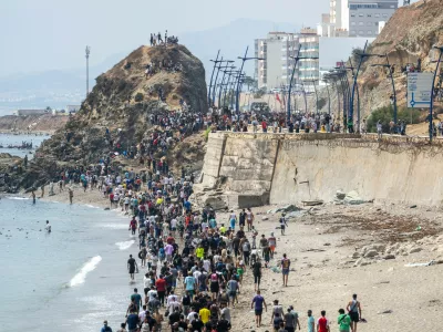 People walk on a beach after attempting to cross from the Moroccan northern town of Fnideq to the Spanish enclave of Ceuta, Friday, July 31, 2026. (AP Photo)