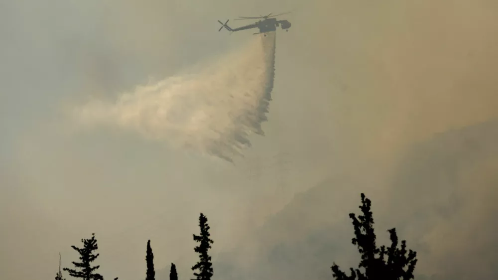 A firefighting helicopter makes a water drop as a wildfire burns near Haidari in Athens, Greece, July 31, 2026. REUTERS/Louiza Vradi