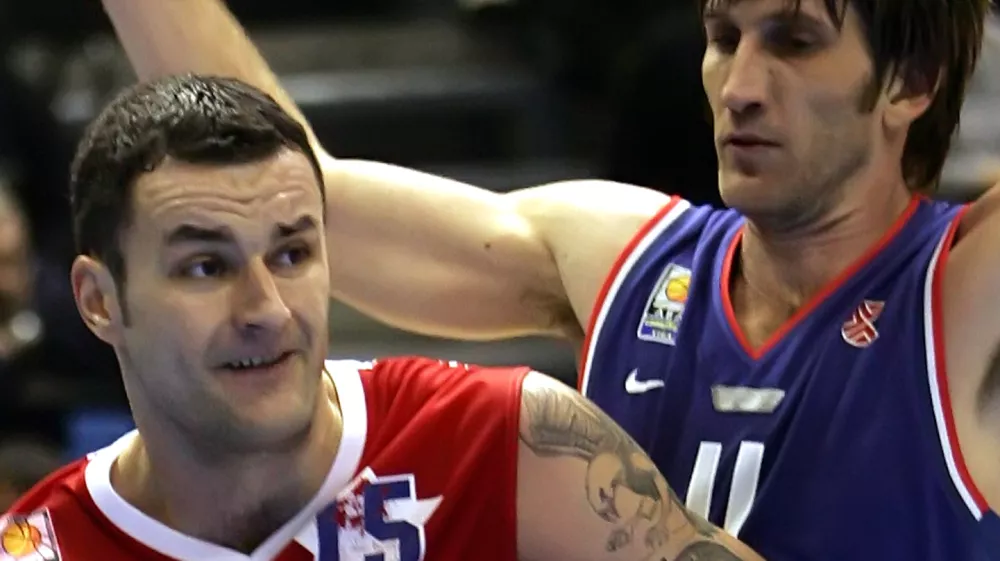 Serbia-Montenegro player Milan Gurovic, left, challenges for the ball with Croatia's Davor Marcelic during the Adriatic League basketball match between Red Star Belgrade and Cibona Zagreb, Saturday, Nov. 12, 2005, in Belgrade. Tattoo on the arm of Gurovic depicts the former ultra-nationalist Serb World War II leader Draza Mihailovic. (AP Photo/Darko Vojinovic)