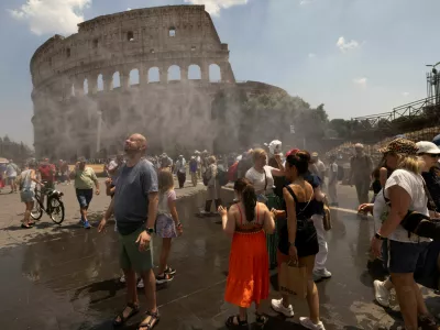 People cool off under a water mist near the Colosseum as Italy's Civil Protection deploys measures to help residents and tourists cope with a heatwave, in Rome, Italy, June 26, 2026. REUTERS/Remo Casilli