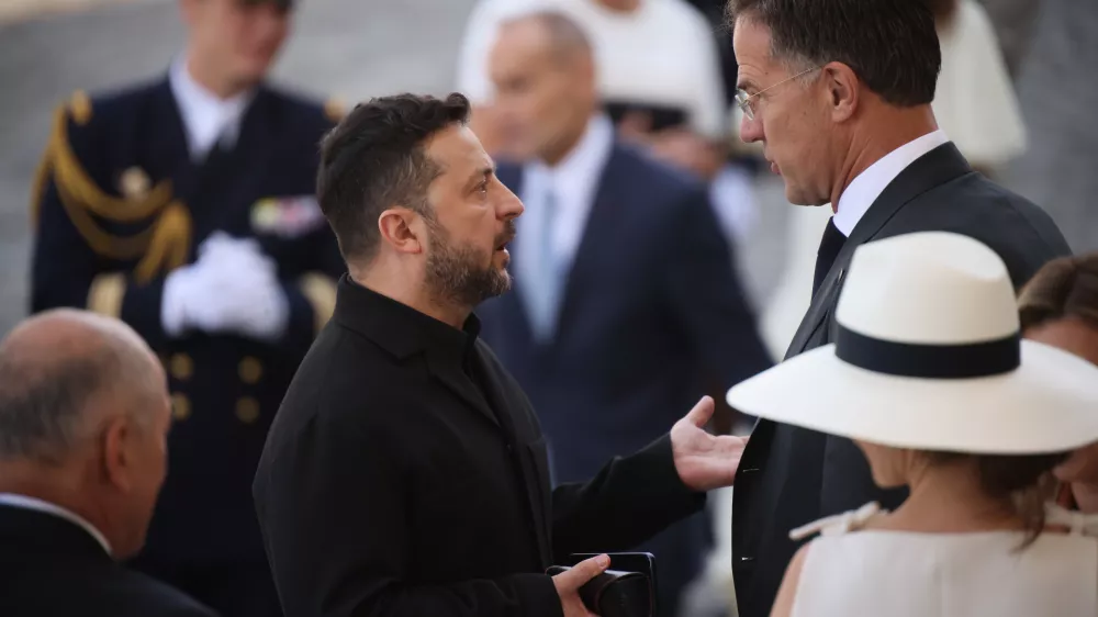 Ukraine's President Volodymyr Zelensky, center left, listens to NATO Secretary-General Mark Rutte as they arrive for the Bastille Day military parade on the Champs-Elysees avenue in Paris, Tuesday, July 14, 2026. (AP Photo/Thomas Padilla)