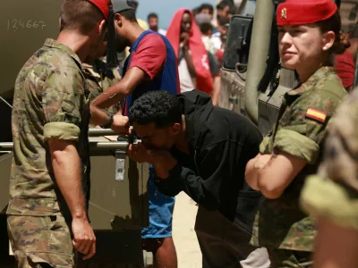A migrant who crossed into Ceuta from Morocco drinks water provided by the Spanish military, following deadly mass crossings of migrants on foot and by sea from Morocco into Spanish territory, in Ceuta, Spain, August 2, 2026. REUTERS/Violeta Santos Moura