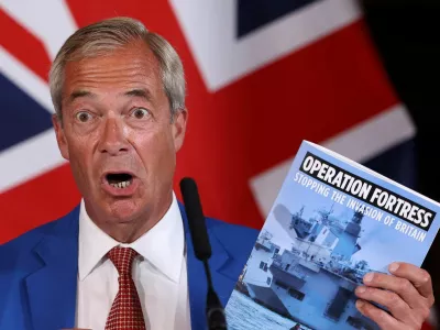 Britain's Reform UK party leader Nigel Farage holds a booklet that reads "Operation Fortress, Stopping the Invasion of Britain" as he speaks during a press conference with the party's home affairs spokesperson Zia Yusuf in London, Britain, August 3, 2026. REUTERS/Toby Melville   TPX IMAGES OF THE DAY