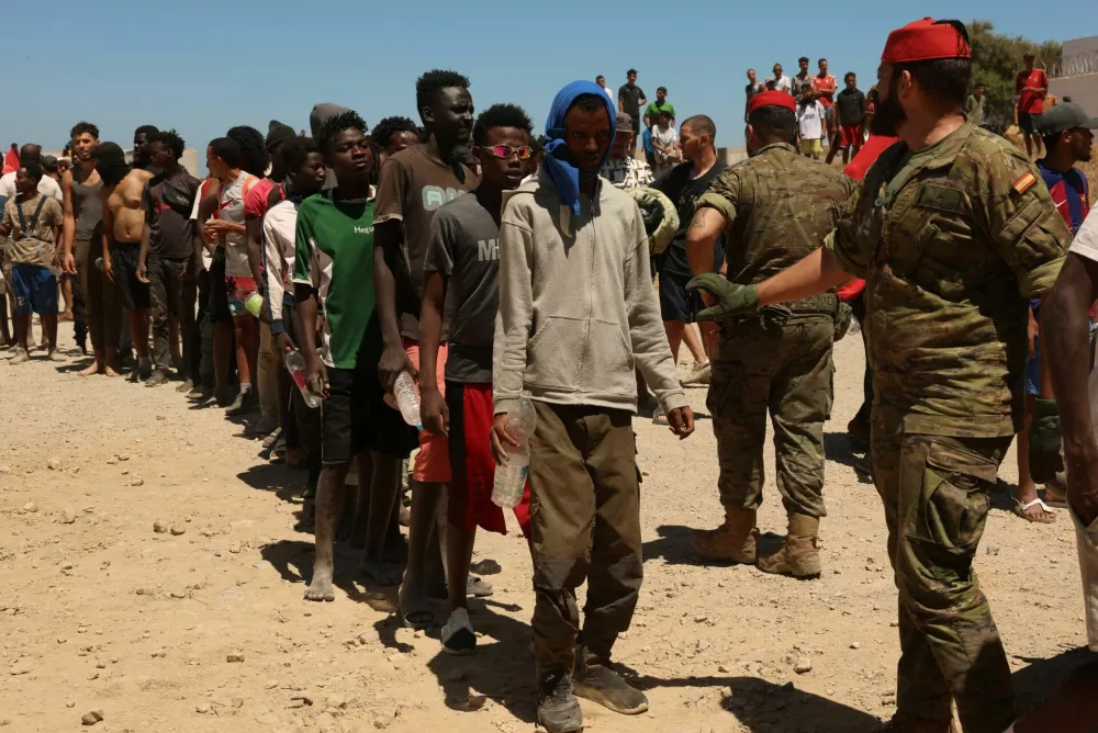 Migrants who crossed into Ceuta from Morocco queue for water provided by the Spanish military, following deadly mass crossings of migrants on foot and by sea from Morocco into Spanish territory, in Ceuta, Spain, August 2, 2026. REUTERS/Violeta Santos Moura / Foto: Violeta Santos Moura