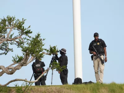Members of the U.S. Secret Service watch before Marine One with President Donald Trump aboard, lands near Trump National Golf Club Los Angeles, Tuesday, Aug. 4, 2026, in Rancho Palos Verdes, Calif. (AP Photo/Mark Schiefelbein)