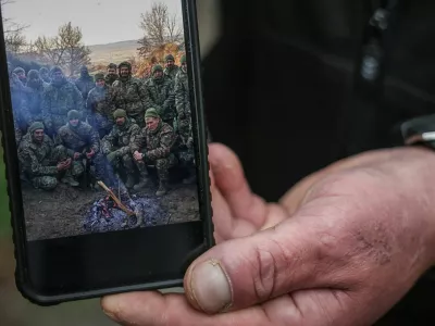Serhii Krynitskyi, 42, a serviceman of the 24th Separate Mechanized Brigade of the Ukrainian Armed Forces, who spent 346 days at an isolated frontline position in the town of Chasiv Yar, Donetsk region, shows a photo of him with fellow soldiers in the beginning of his service in November 2024, on his first day back on duty after recovery, amid Russia's attack on Ukraine, in the frontline city of Kramatorsk in Donetsk region, Ukraine, May 27, 2026. REUTERS/Alina Smutko