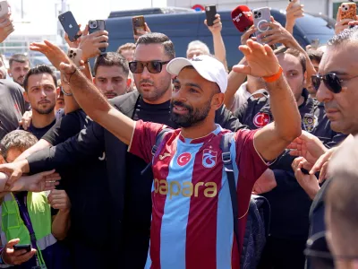 Egypt's Mohamed Salah wearing his new Trabzonspor team jersey gestures to supporters as he arrives at the airport in Istanbul, Turkey, Wednesday, Aug. 5, 2026. (Samet Yalcin/DIA Photo via AP)