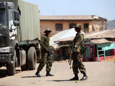 FILE PHOTO: Soldiers stand guard along a road in Nigeria's central city of Jos January 20, 2010. REUTERS/Akintunde Akinleye/File Photo