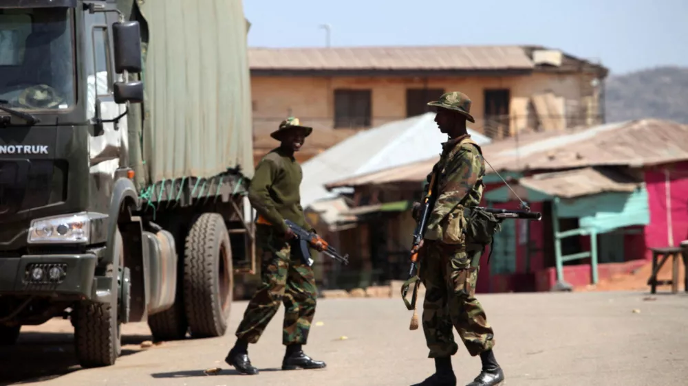 FILE PHOTO: Soldiers stand guard along a road in Nigeria's central city of Jos January 20, 2010. REUTERS/Akintunde Akinleye/File Photo