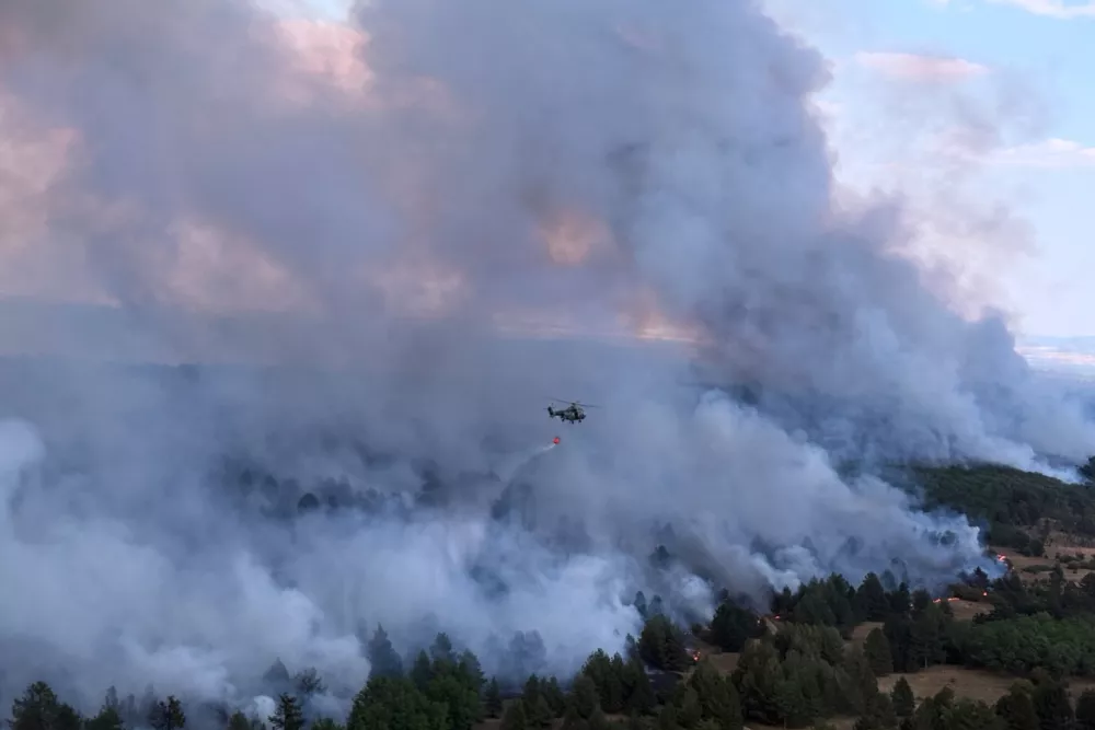 In this photograph made available by the Serbian Ministry of Interior, a Serbian Police helicopter battles a fire in Deliblatska Pescara (Deliblato Sands), 70 kilometers north-west of Belgrade, Serbia, on Wednesday, Aug. 5, 2026. (Serbian Ministry of Interior via AP)