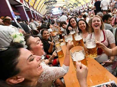 Visitors raise their beer mugs during the official opening day of the 190th Oktoberfest, the world's largest beer festival in Munich, Germany, September 20, 2025. REUTERS/Angelika Warmuth