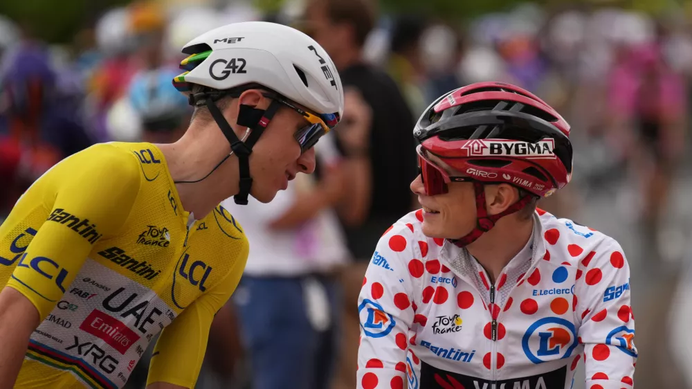 Slovenia's Tadej Pogacar, wearing the overall leader's yellow jersey, talks to Denmark's Jonas Vingegaard, wearing the best climber's dotted jersey, before the start of the eleventh stage of the Tour de France cycling race with start in Vichy and finish in Nevers, France, Wednesday, July 15, 2026. (AP Photo/Mosa'ab Elshamy)