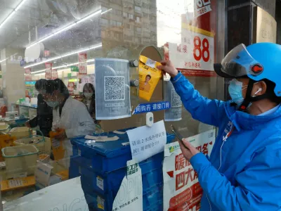 A delivery worker picks up a medicine order from a pharmacy in Huangpu district, amid the coronavirus disease (COVID-19) outbreak in Shanghai, China April 17, 2022. Picture taken April 17, 2022. China Daily via REUTERS ATTENTION EDITORS - THIS IMAGE WAS PROVIDED BY A THIRD PARTY. CHINA OUT.