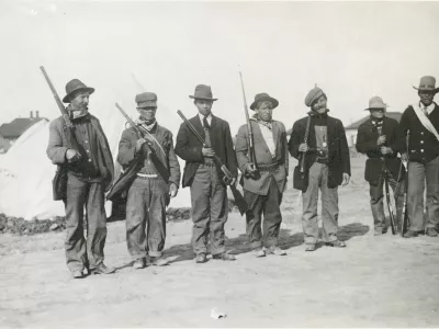 Oboroženi stavkajoči v &scaron;otorskem naselju Ludlow leta 1914. Na fotografiji je mogoče videti bele &scaron;otore, ki jih je zagotovil sindikat United Mine Workers of America, ter pu&scaron;ke z vzvodnim mehanizmom, ki so bile raz&scaron;irjene na obeh straneh spopada. / Foto: Wikipedija