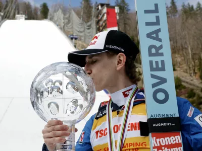 Ski Jumping - FIS Ski Jumping World Cup - Planica, Slovenia - March 30, 2025 Austria's Daniel Tschofenig kisses a trophy after finishing as the overall winner of the FIS Ski Jumping World Cup REUTERS/Borut Zivulovic