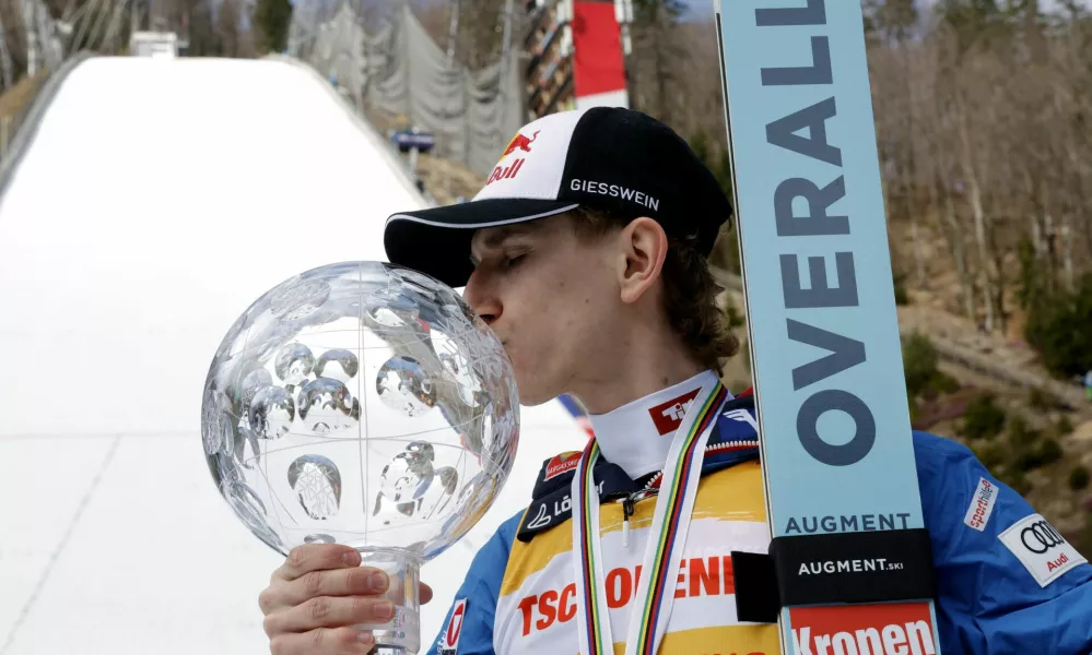 Ski Jumping - FIS Ski Jumping World Cup - Planica, Slovenia - March 30, 2025 Austria's Daniel Tschofenig kisses a trophy after finishing as the overall winner of the FIS Ski Jumping World Cup REUTERS/Borut Zivulovic