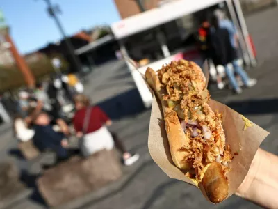 A tourist holds up a hotdog ordered from one of the classic fast food stands in central Copenhagen, Denmark, July 23, 2026. REUTERS/Tom Little