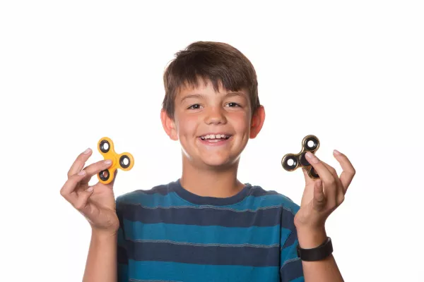 Boy on White Background Playing With Two Fidget Spinners