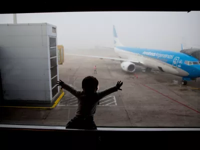 FILE - A child watches a plane at the Jorge Newbery airport in Buenos Aires, Argentina, April 14, 2016. (AP Photo/Natacha Pisarenko, File)