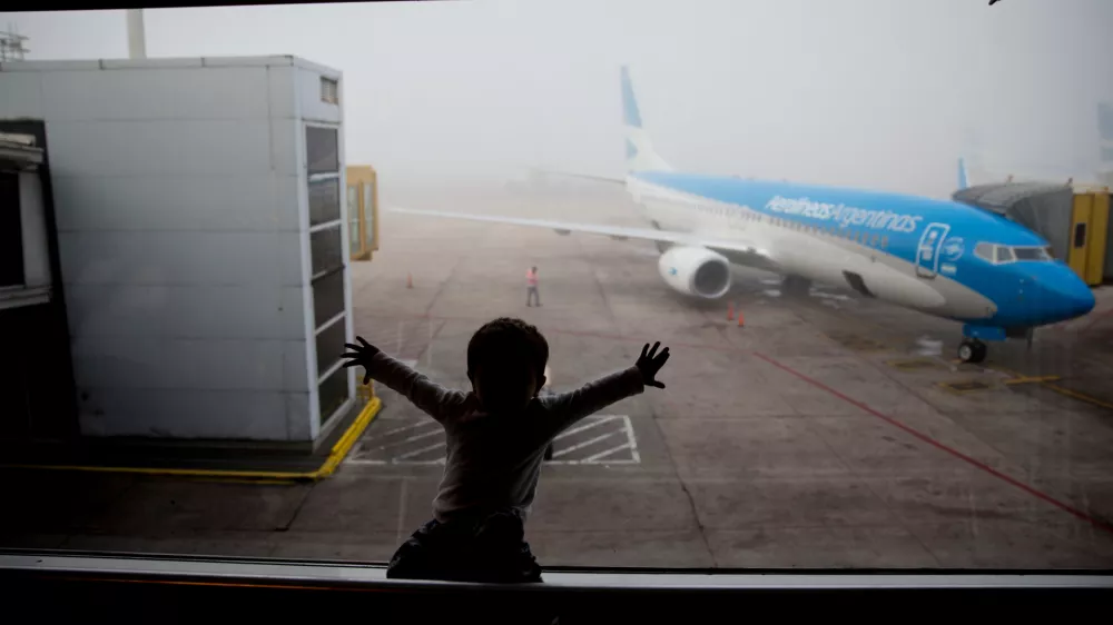 FILE - A child watches a plane at the Jorge Newbery airport in Buenos Aires, Argentina, April 14, 2016. (AP Photo/Natacha Pisarenko, File)