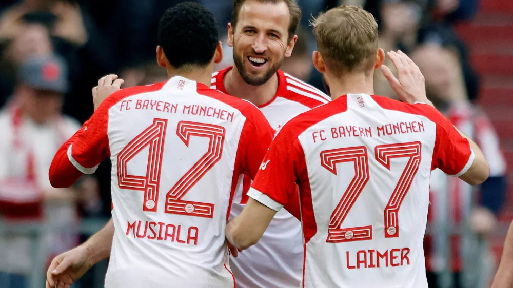 Soccer Football - Bundesliga - Bayern Munich v 1. FSV Mainz 05 - Allianz Arena, Munich, Germany - March 9, 2024 Bayern Munich's Harry Kane celebrates scoring their seventh goal to complete his hat-trick with Jamal Musiala and Konrad Laimer REUTERS/Michaela Stache DFL REGULATIONS PROHIBIT ANY USE OF PHOTOGRAPHS AS IMAGE SEQUENCES AND/OR QUASI-VIDEO. TPX IMAGES OF THE DAY