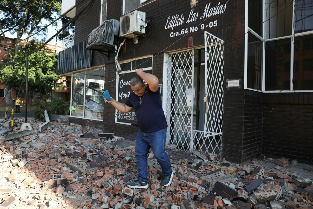 A man leaves an apartment building after an earthquake struck Cali, Colombia, Monday, Aug. 10, 2026. (AP Photo/Santiago Saldarriaga)