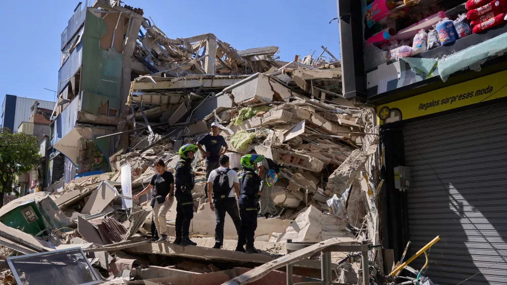 Police look at a building damaged after an earthquake struck Pereira, Colombia, Monday, Aug. 10, 2026. (AP Photo/Vladimir Encima)