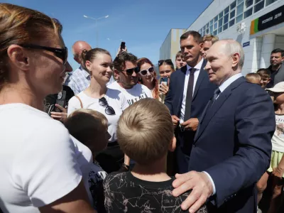 Russian President Vladimir Putin, right, interacts with local residents in Kurilsk on the Iturup Island, the largest of the Kuril Islands of Russia's far-east, Thursday, Aug. 13, 2026. (Gavriil Grigorov, Sputnik, Kremlin Pool Photo via AP)