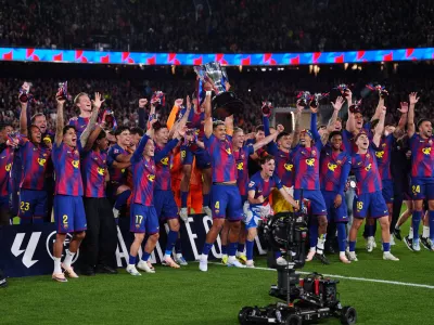 Barcelona's Ronald Araujo lifts the trophy after defeating Real Madrid 2-0 to win the Spanish La Liga soccer championship with three rounds to spare, in Barcelona, Spain, Sunday, May 10, 2026. (AP Photo/Joan Mateu Parra)