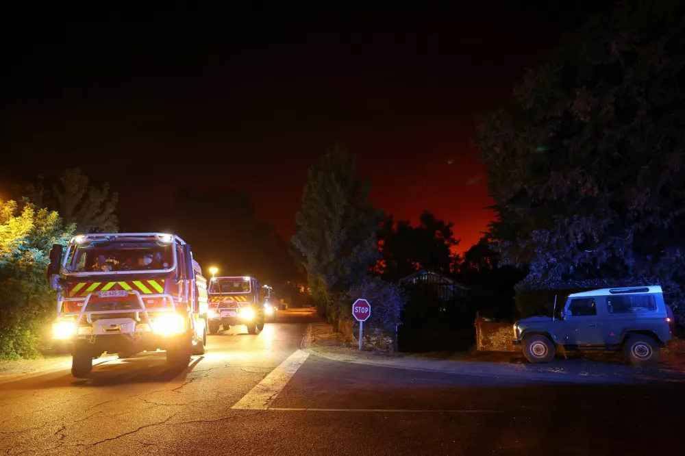 Firefighters operate following a wildfire burning in Luglon, France, August 13, 2026. REUTERS/Stephanie Lecocq