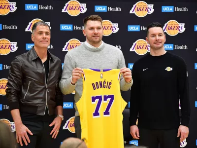 Feb 4, 2025; El Segundo, CA, USA; Los Angeles Lakers guard Luka Doncic poses for photos with general manager Rob Pelinka and head coach JJ Redick at UCLA Health Training Center. Mandatory Credit: Gary A. Vasquez-Imagn Images