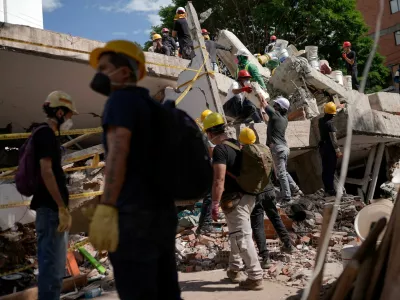 People clean up debris, as search and rescue operations are under way at the site of a destroyed Cantabria building, following the earthquake in Cali, Colombia, August 13, 2026. REUTERS/Sergio Acero