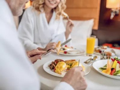 Breakfast time. A couple in white robes having breakfast and looking pleased