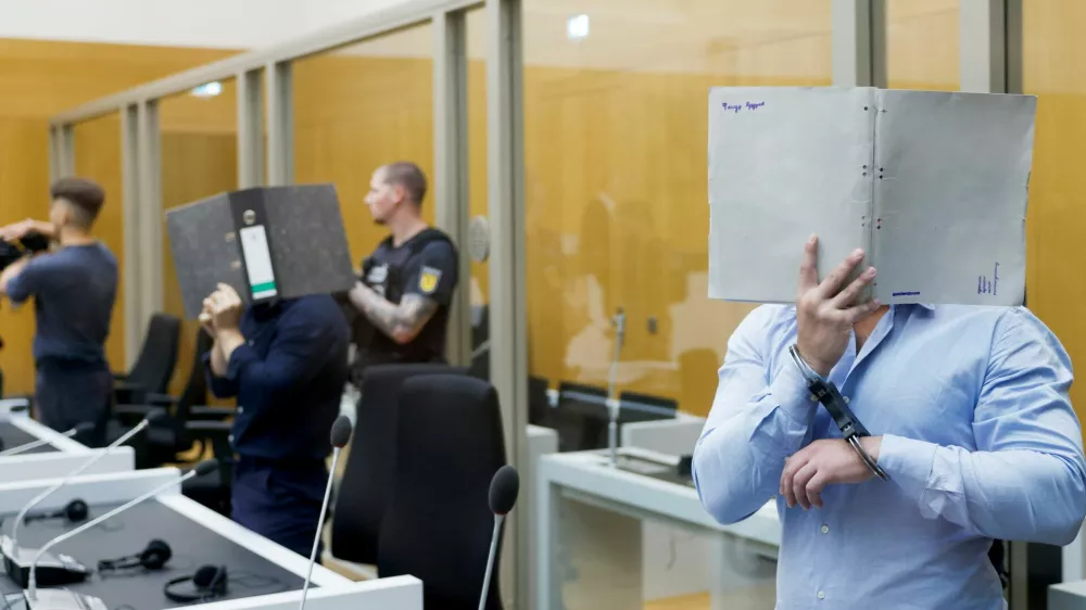 Defendants Daniil B., Vladyslav T. and Yevhen B. cover their faces as they arrive in the courtroom, where the court is expected to conclude the trial against the three Ukrainian nationals suspected of conspiracy to commit arson attacks on behalf of a Russian intelligence service, at the Stuttgart Higher Regional Court (Oberlandesgericht Stuttgart) in Stuttgart, Germany, August 18, 2026. REUTERS/Heiko Becker
