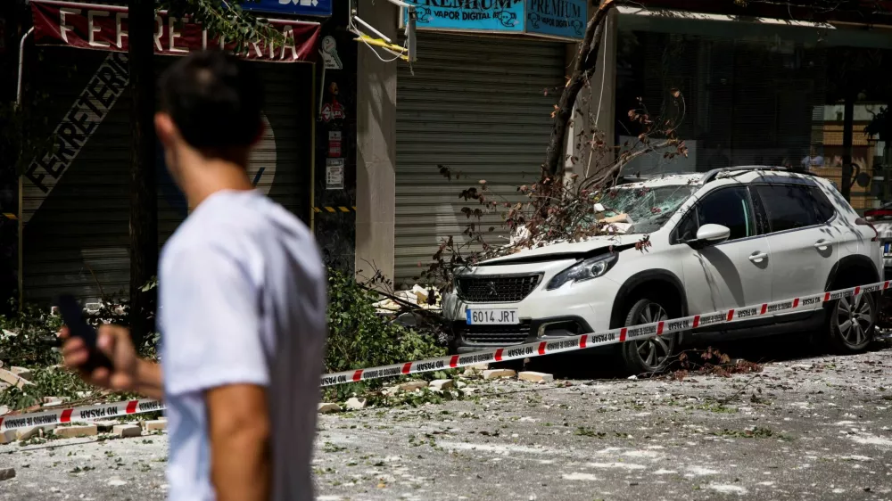 A fallen tree branch lies atop a damaged vehicle on a street in the aftermath of an earthquake that struck southern Spain, in Granada, Spain, August 18, 2026. REUTERS/Fermin Rodriguez