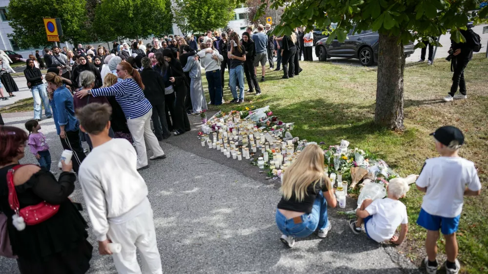 Fagersta residents leave flowers and candles at a makeshift memorial outside a shool in Fagersta, Sweden, on Aug. 22, 2026, the day after a 17-year-old girl was killed and three others injured at the school by a man with a sword.,Image: 1127307155, License: Rights-managed, Restrictions:, Model Release: no 