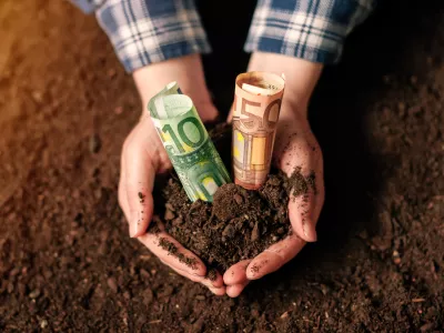 Hands with fertile soil and euro money banknotes, female farmer handful of cultivated land that makes profit and steady income from sustainable agricultural activity like organic growth of crops