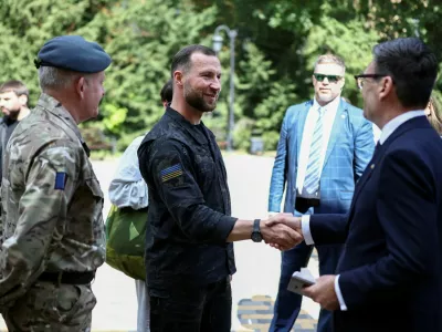 British Prime Minister Andy Burnham shakes hands with Ukraine's Defence Minister Yevhenii Khmara as Britain's Chief of the Defence Staff Air Chief Marshal Richard Knighton looks on, after he met patients wounded in the war at the Main Military Hospital, supported by the David Nott Foundation, a UK charity who have trained over 1,000 Ukrainian surgeons, anaesthetists and other healthcare workers, in Kyiv, Ukraine August 24, 2026. HENRY NICHOLLS/Pool via REUTERS