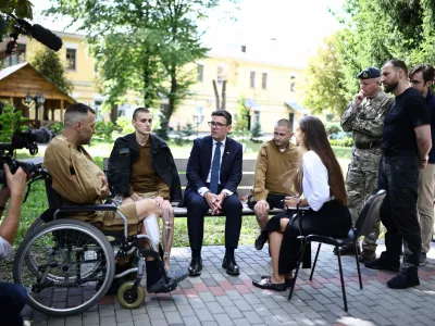 Britain's prime minister Andy Burnham gestures as he meets patients wounded in the war at the Main Military Hospital, supported by the David Nott Foundation, a UK charity who have trained over 1,000 Ukrainian surgeons, anaesthetists and other healthcare workers, in Kyiv on August 24, 2026. (Henry Nicholls/Pool photo via AP)