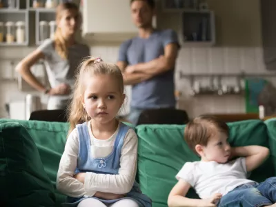 Frustrated kid girl feels upset, offended or bored ignoring avoiding worried parents and brother, little sad sister not talking to child boy after fight sulking sitting on couch, siblings rivalry