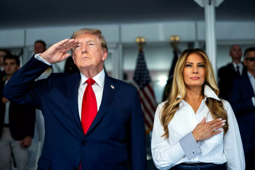 U.S. President Donald Trump with first lady Melania Trump during the National Anthem at the start of the Freedom 250 Grand Prix race on the streets of Washington, D.C., U.S., August 23, 2026. Doug Mills/Pool via REUTERS